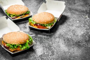 Three burgers in paper boxes